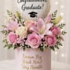 Soft pink roses and pale lilies arranged in a compact round gift