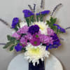 Purple and white chrysanthemum bouquet in a dark vase