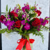 un detalle en vase de agua lleva follaje verde, rosas rojas,stock moradosolidagogipsofilia