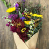 Bouquet of mixed flowers wrapped in brown paper with a red ribbon