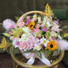 An enchanting garden-style luxury basket overflowing with delicate blush and pastel blooms