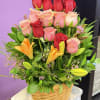 Basket arrangement of red and pink roses with orange lilies
