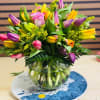 Round glass vase with mix tulips and other flowers 