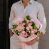 A lush, rounded hand-tied bouquet in soft shades of blush pink, cream