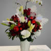 Deep red roses paired with pure white lilies and hydrangeas create a