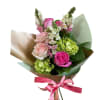 Hand-tied bouquet of pink roses, white snapdragons, and green hydrangeas wrapped in paper with a pink ribbon.