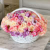 Basket of pink, cream, and purple flowers on a table