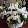 White roses and daisy-like flowers in a wicker basket