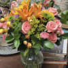 Pink roses and orange lilies in a glass vase