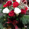 Red and white roses with carnations in a vase, accented by candy canes