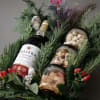 Gift basket with wine, jars of nuts, and evergreen sprigs