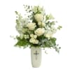 Pure white roses and lilies rise from a tall cream ceramic vase