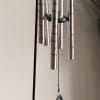 A bright floral topper crowns a polished silver wind chime for a