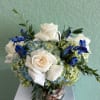 A low compact arrangement of blue and white flowers such as hydrangeas
