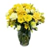 Yellow roses and daisies arranged in a clear glass vase