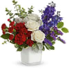 Bold clusters of red carnations and crisp white roses meet soaring blue