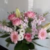 Pink and white mixed bouquet with roses, lilies, and daisies in a glass vase