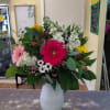 A  vase filled with assorted colored gerbera daisies, Ying yang button