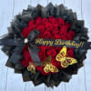 Red rose bouquet with black wrapping, a birthday ribbon, and butterfly decorations
