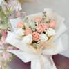 Bouquet of blush and white roses wrapped in white paper