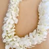 White flower lei on a tan background