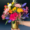 Vivid yellow calla lilies arch above a lush mix of roses and
