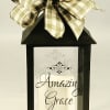 A charming black lantern with a warm white pillar candle inside creates
