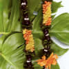 Two floral leis with orange and yellow flowers on large green leaves.