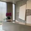 Purple orchid arrangement in a white bowl on a concrete counter