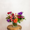Mixed bouquet of roses and purple flowers in a glass vase
