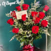 Bouquet of red roses in a green vase with a ribbon bow
