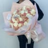 Large bouquet of blush and cream roses wrapped in pale pink paper