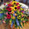 Large colorful floral arrangement with gerbera daisies, roses, and sunflowers