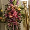 Tall floral spray with pink and purple flowers on a stand