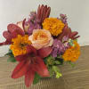 In the clear glass, square vase combinations or orange flowers lilies, marigold