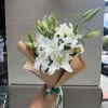 A cluster of large white lilies takes center stage in this white