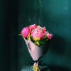 Pink peony bouquet wrapped in dark paper with a black ribbon