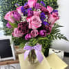 A lush cluster of pink roses and velvety purple blooms makes this