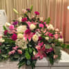 Large pink and white floral arrangement with lilies and roses on a table
