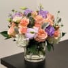 Mixed pastel bouquet of roses and hydrangeas in a clear glass vase