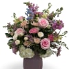 Soft blush, cream, lavender, and pale peach blooms spill in a lush