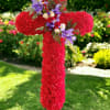 Red floral cross on a stake with purple and white accents