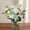 White roses and lilies arranged in a clear glass vase