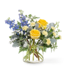 Bright yellow roses, soft butter‑cream carnations, and striking blue delphinium come together