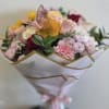 Bouquet of pink, white, and yellow flowers wrapped in white paper
