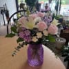 Pale pink roses and white lilies mingle with lavender blooms and cream