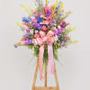 Pastel pink roses and airy daisy-like blooms form a gentle, uplifting statement