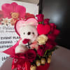 Heart-shaped rose arrangement with a teddy bear and chocolates