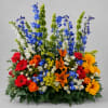 Tall blue delphinium spires crown this Colorful Tribute Table Arrangement, giving it