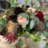 Mixed bouquet with a pale pink rose and burgundy blooms in a glass vase